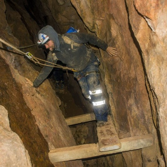 Mine explorer climbing a mineshaft near St. Just, Cornwall