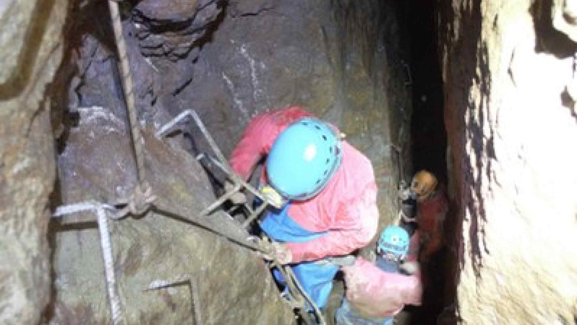 Mine explorer descending a ladder in a Cornish tin mine.